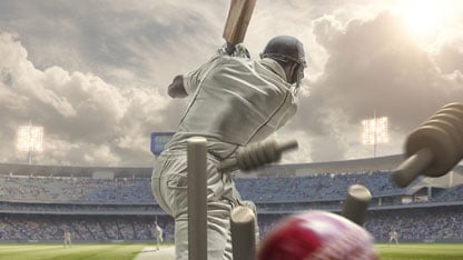 Rear view Of cricket ball hitting stumps behind batsman